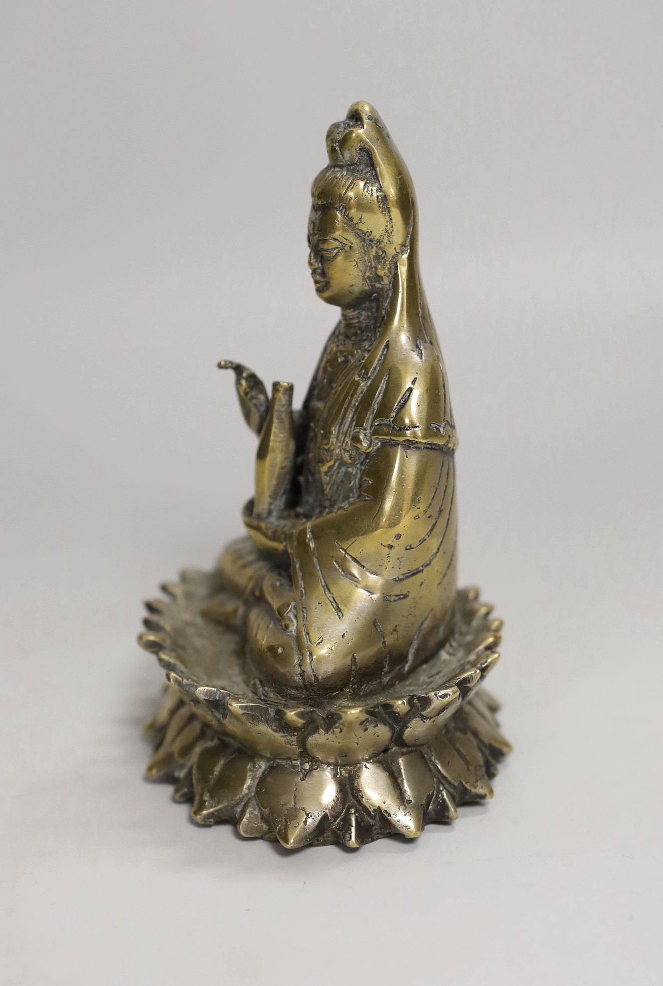 A Chinese bronze seated figure of Guanyin, 13cm
